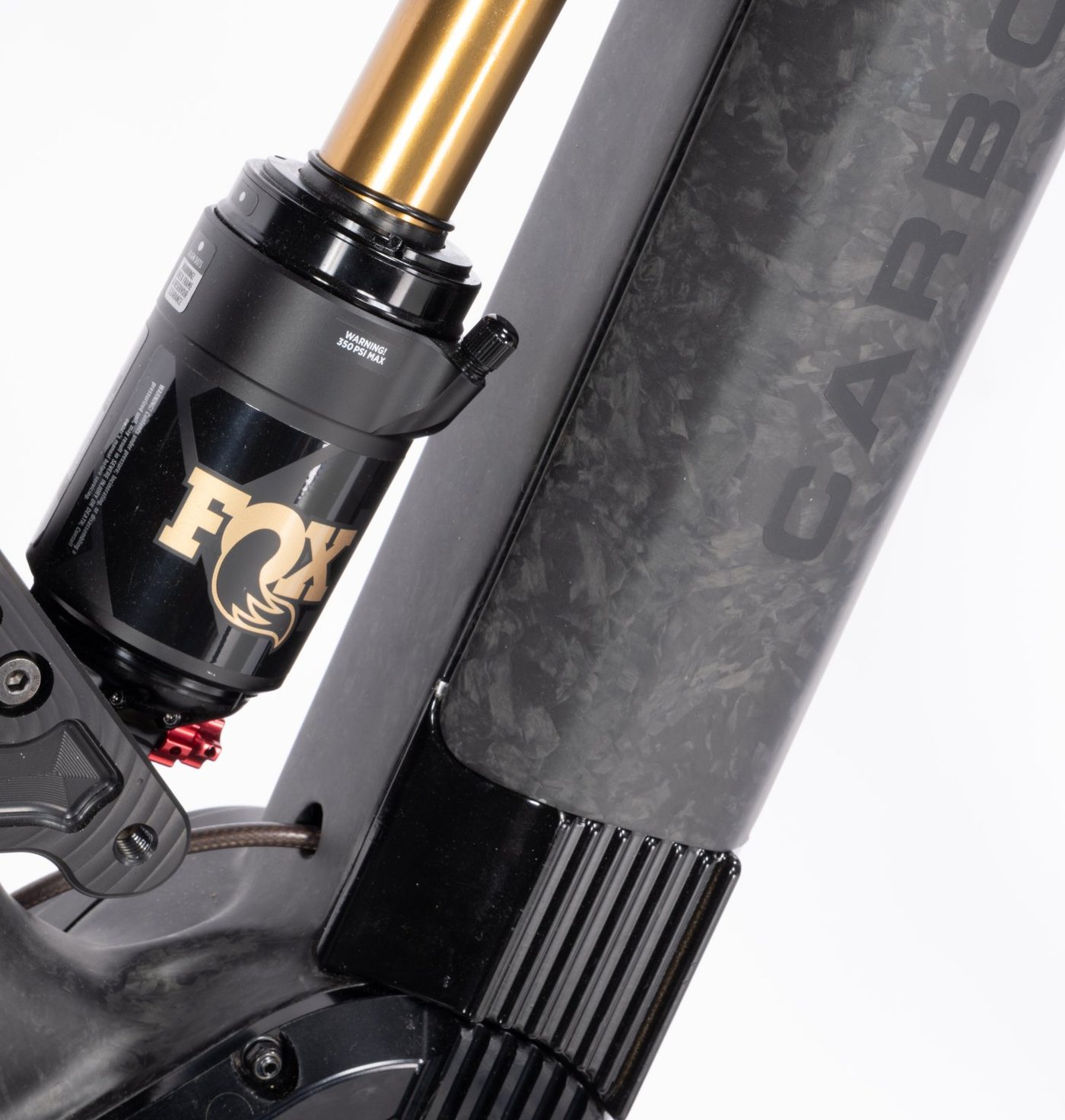 Close-up of the forged-carbon down tube with its marbled fiber texture, next to a Fox Float X2 Factory shock